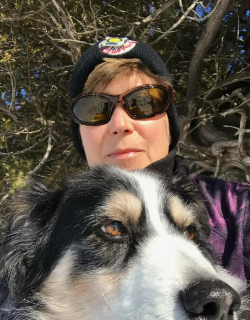 Dr. Heather wearing sunglasses and posing with her dog
